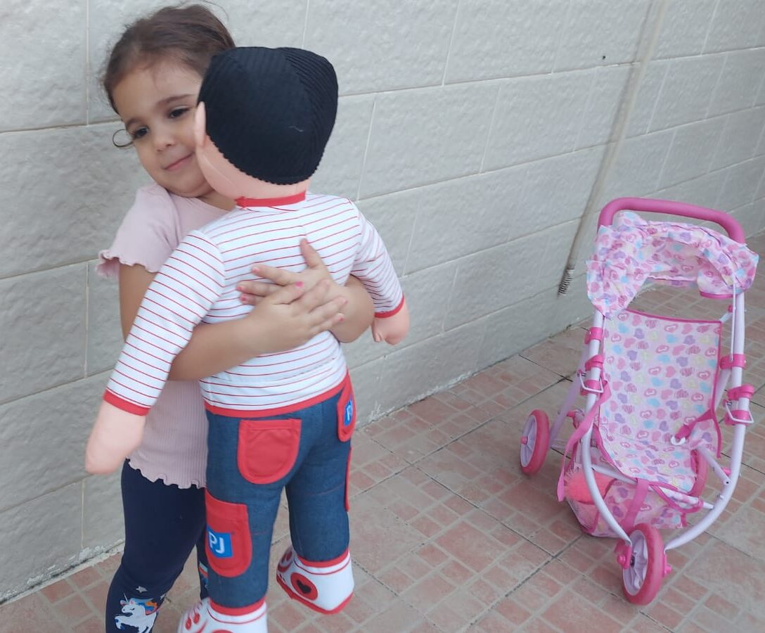 ילדה מחבקת בובה בפיג'מה